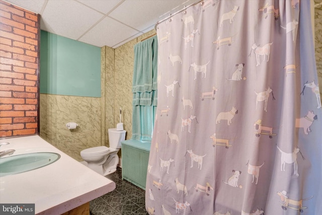 full bathroom featuring toilet, curtained shower, vanity, and a paneled ceiling