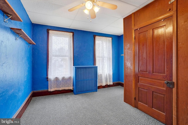 unfurnished bedroom featuring carpet floors, a drop ceiling, and a textured wall