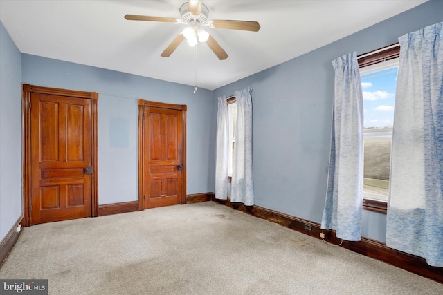 unfurnished bedroom with carpet floors, ceiling fan, and baseboards