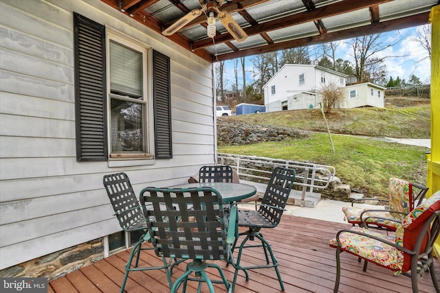 wooden deck featuring outdoor dining space and a ceiling fan