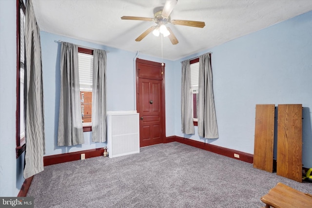 unfurnished bedroom with a ceiling fan, carpet, and baseboards