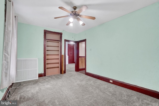 unfurnished bedroom featuring ceiling fan, radiator heating unit, carpet flooring, and baseboards