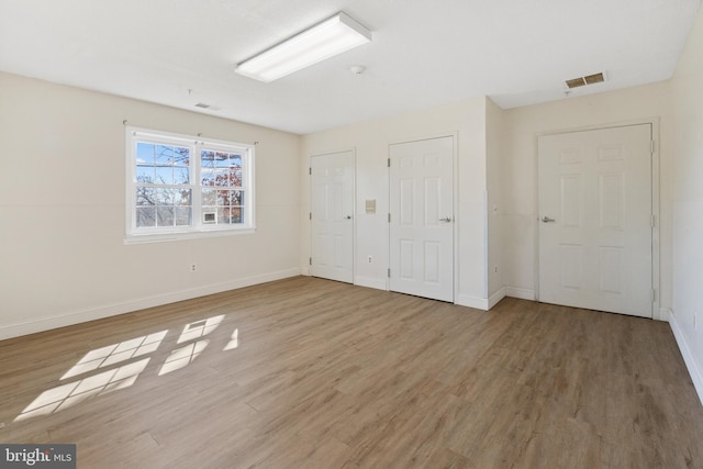 unfurnished bedroom with baseboards, visible vents, and light wood finished floors