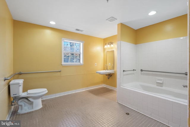 full bathroom with tiled tub, visible vents, toilet, and tile patterned floors