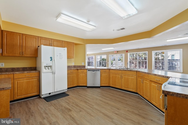 kitchen featuring light wood-style flooring, visible vents, dishwasher, white fridge with ice dispenser, and brown cabinetry