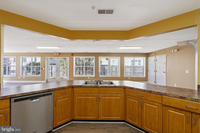 kitchen featuring visible vents, brown cabinets, french doors, stainless steel dishwasher, and a sink