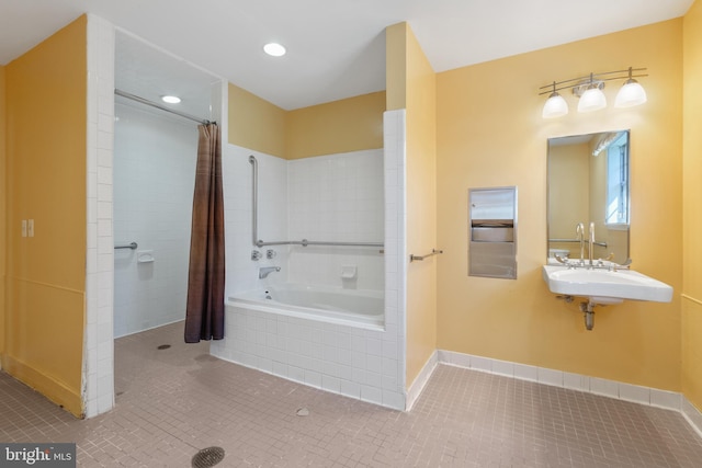 bathroom with tile patterned flooring, tiled shower, a sink, and tiled tub