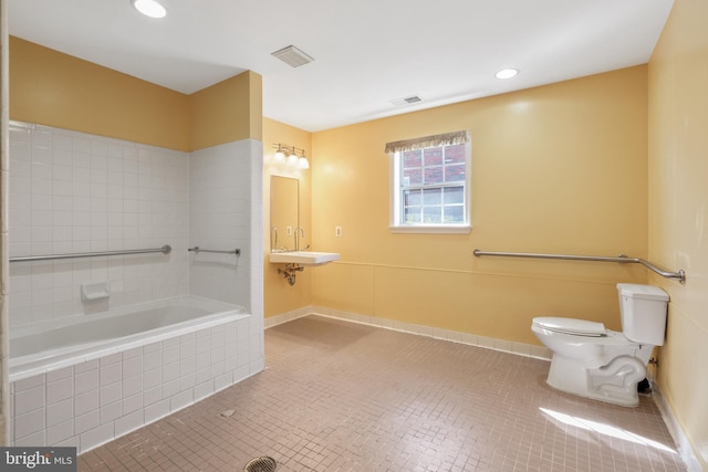 bathroom with toilet, tile patterned flooring, tiled bath, and visible vents