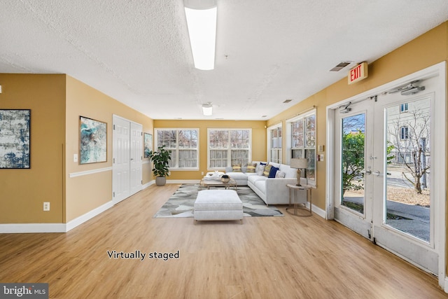 unfurnished sunroom with french doors, visible vents, and plenty of natural light