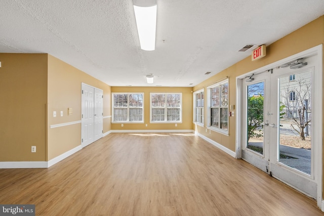 unfurnished sunroom featuring french doors, visible vents, and a healthy amount of sunlight