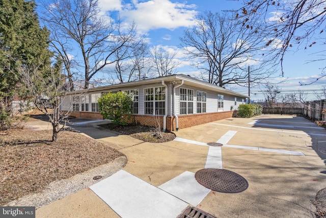 view of side of home with fence and brick siding