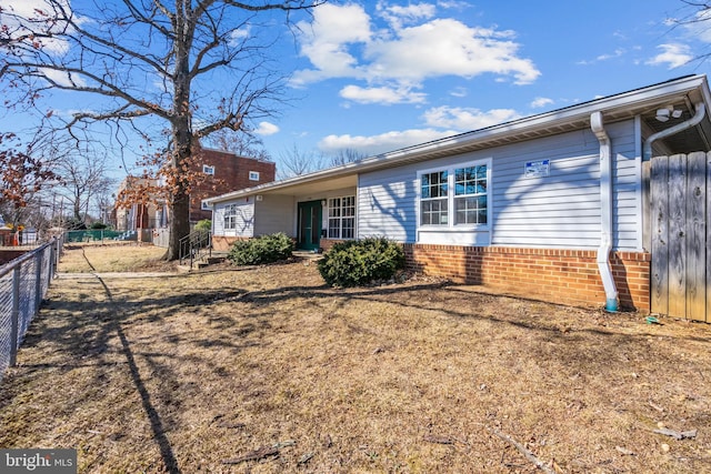 view of front of home with brick siding and fence