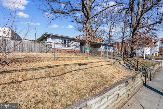 view of front of home with a fenced front yard and brick siding