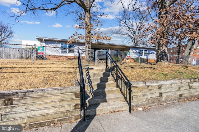 ranch-style home featuring a fenced front yard and a gate