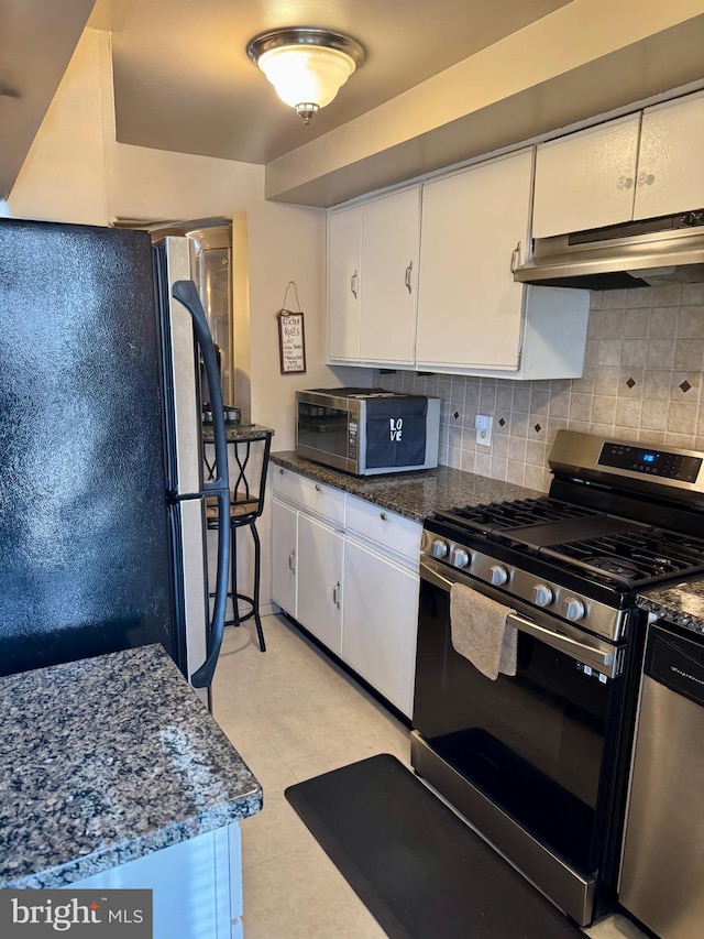 kitchen featuring stainless steel appliances, tasteful backsplash, under cabinet range hood, and white cabinets