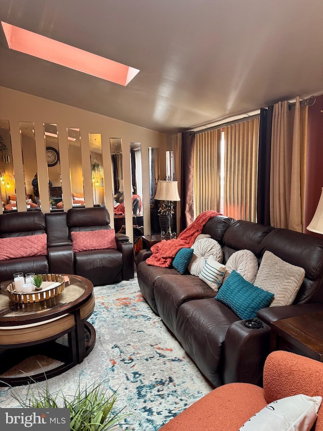 living area featuring vaulted ceiling with skylight