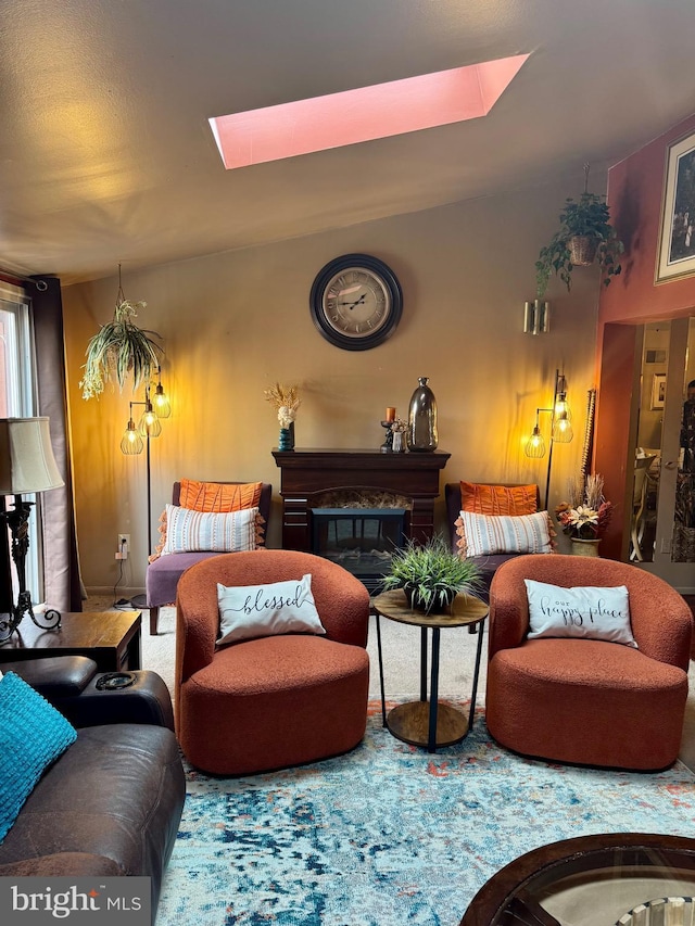 sitting room featuring a skylight and a glass covered fireplace