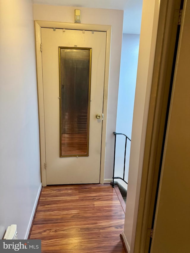 hallway with baseboards and wood finished floors