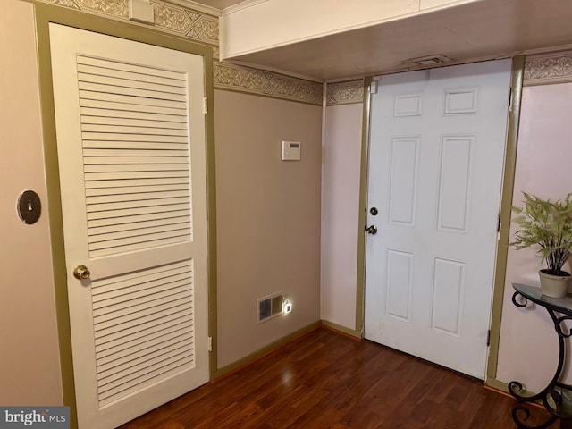 foyer with baseboards, visible vents, and dark wood-type flooring