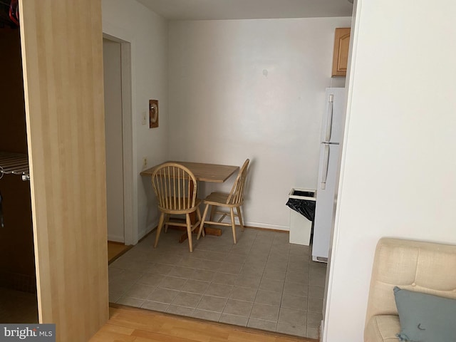 dining space with light wood-type flooring and baseboards