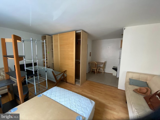 bedroom with wood finished floors and freestanding refrigerator