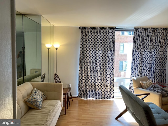 sitting room featuring a wall of windows and light wood-style flooring