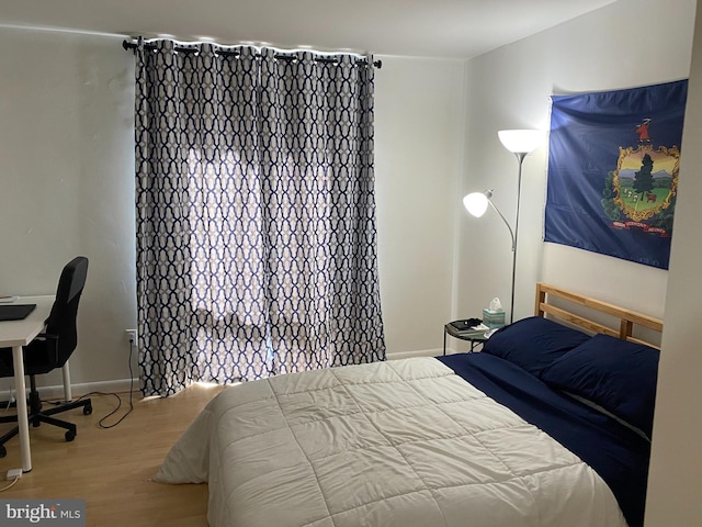 bedroom featuring baseboards and wood finished floors