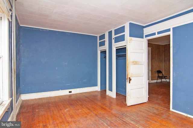 unfurnished bedroom featuring wood-type flooring and baseboards