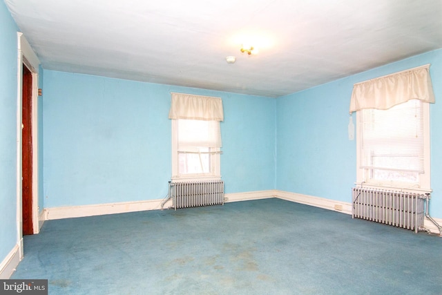 empty room with carpet, baseboards, and radiator heating unit