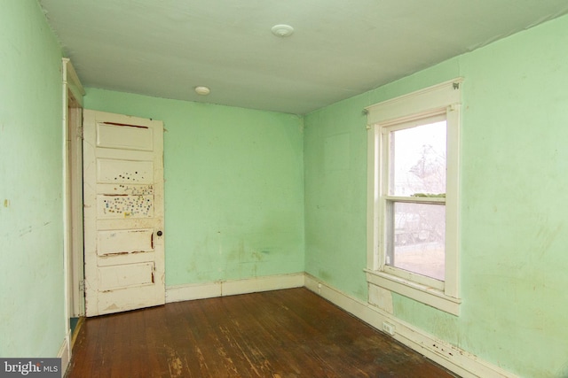 empty room with wood-type flooring and baseboards