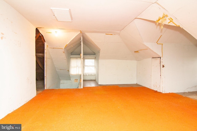 additional living space featuring lofted ceiling and visible vents