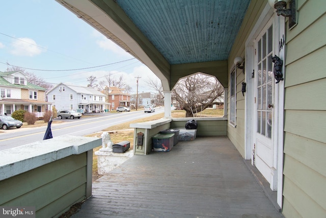 wooden terrace featuring a porch and a residential view