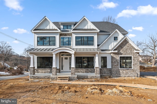 view of front of house featuring a standing seam roof, stone siding, metal roof, and board and batten siding