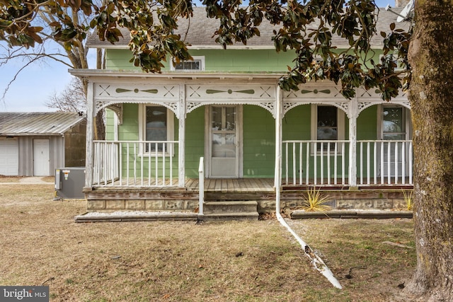 view of front of house featuring a garage, covered porch, and a shingled roof