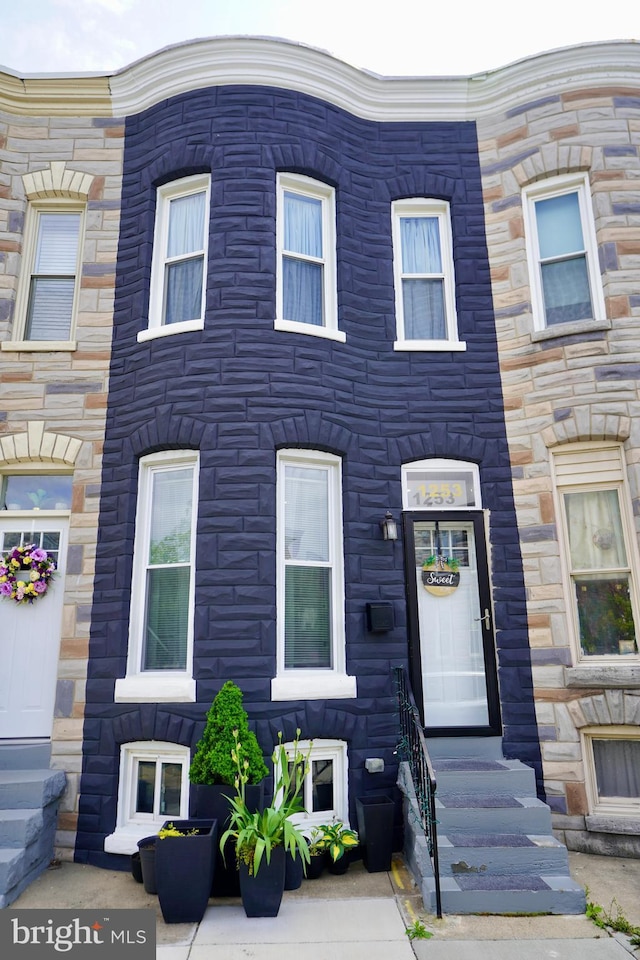 townhome / multi-family property featuring stone siding