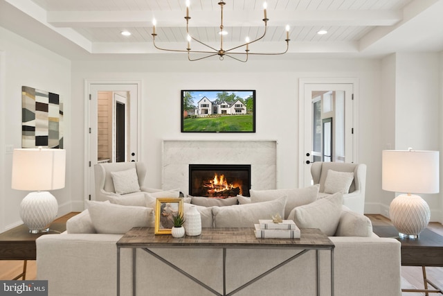 living room featuring beam ceiling, a fireplace, and wood finished floors