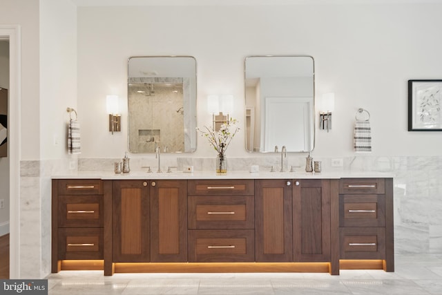 full bath with double vanity, walk in shower, and a sink