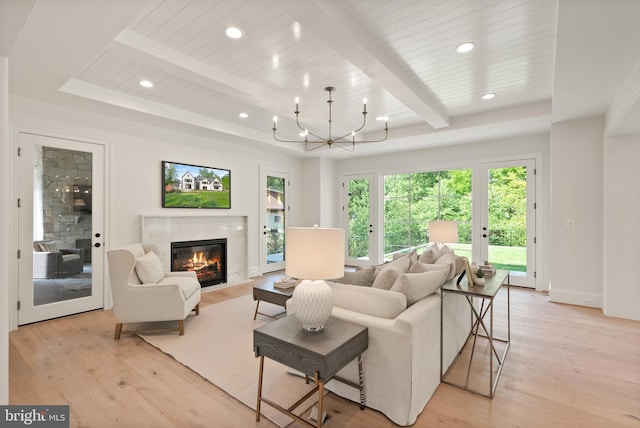 living area with recessed lighting, a high end fireplace, beam ceiling, and light wood-style floors