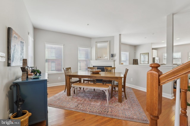 dining room with a healthy amount of sunlight, wood finished floors, and baseboards