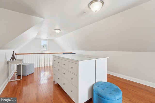 additional living space with lofted ceiling, light wood-style flooring, and baseboards