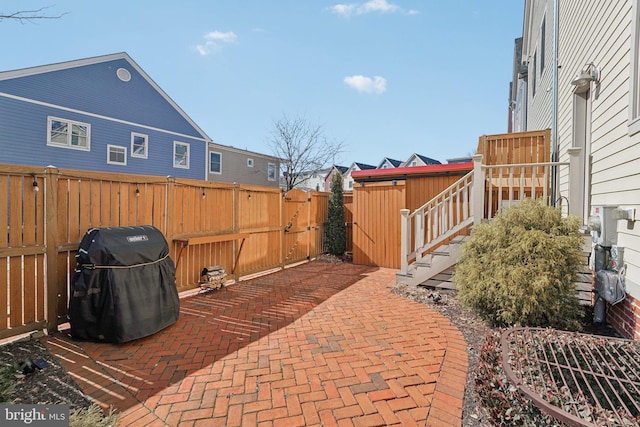 view of patio / terrace with area for grilling, a fenced backyard, and a gate