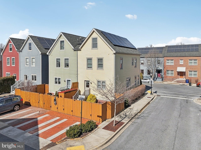 exterior space with sidewalks, a gate, a residential view, and curbs