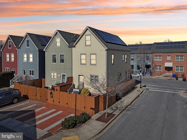 view of road featuring sidewalks, a residential view, a gate, and curbs