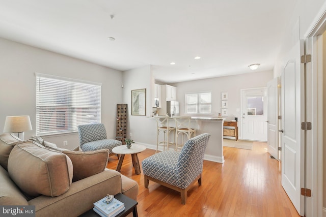 living area with recessed lighting, baseboards, and light wood finished floors