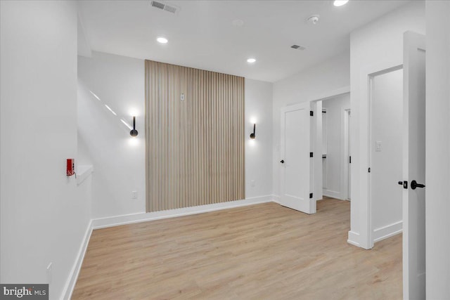 unfurnished room with light wood finished floors, baseboards, visible vents, and recessed lighting