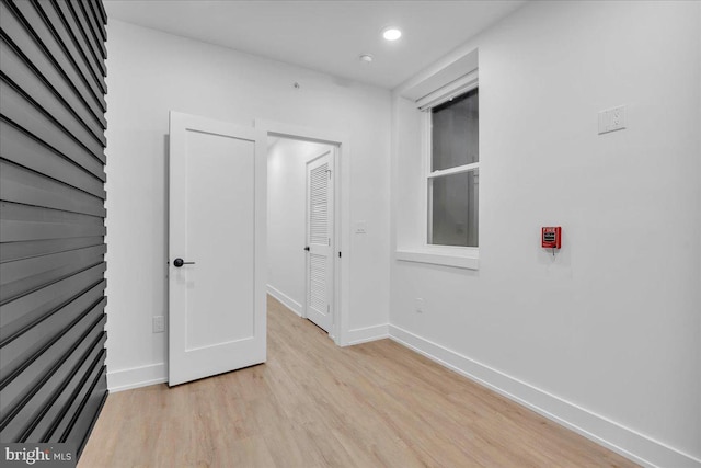 spare room with recessed lighting, baseboards, and light wood finished floors