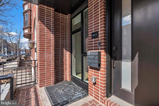 doorway to property with brick siding and a balcony