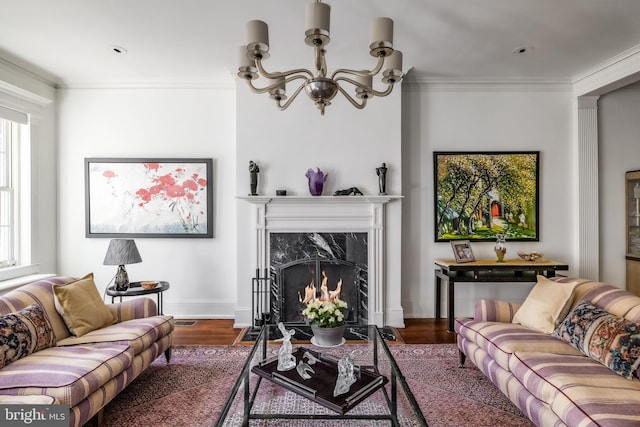 living room with crown molding, a notable chandelier, and plenty of natural light