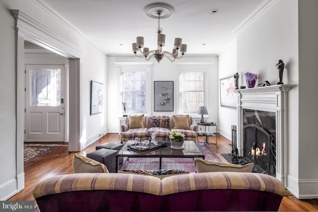 living area featuring crown molding, wood finished floors, a high end fireplace, and a chandelier