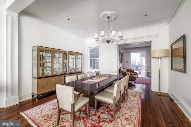 dining space with a chandelier, wood finished floors, and ornamental molding